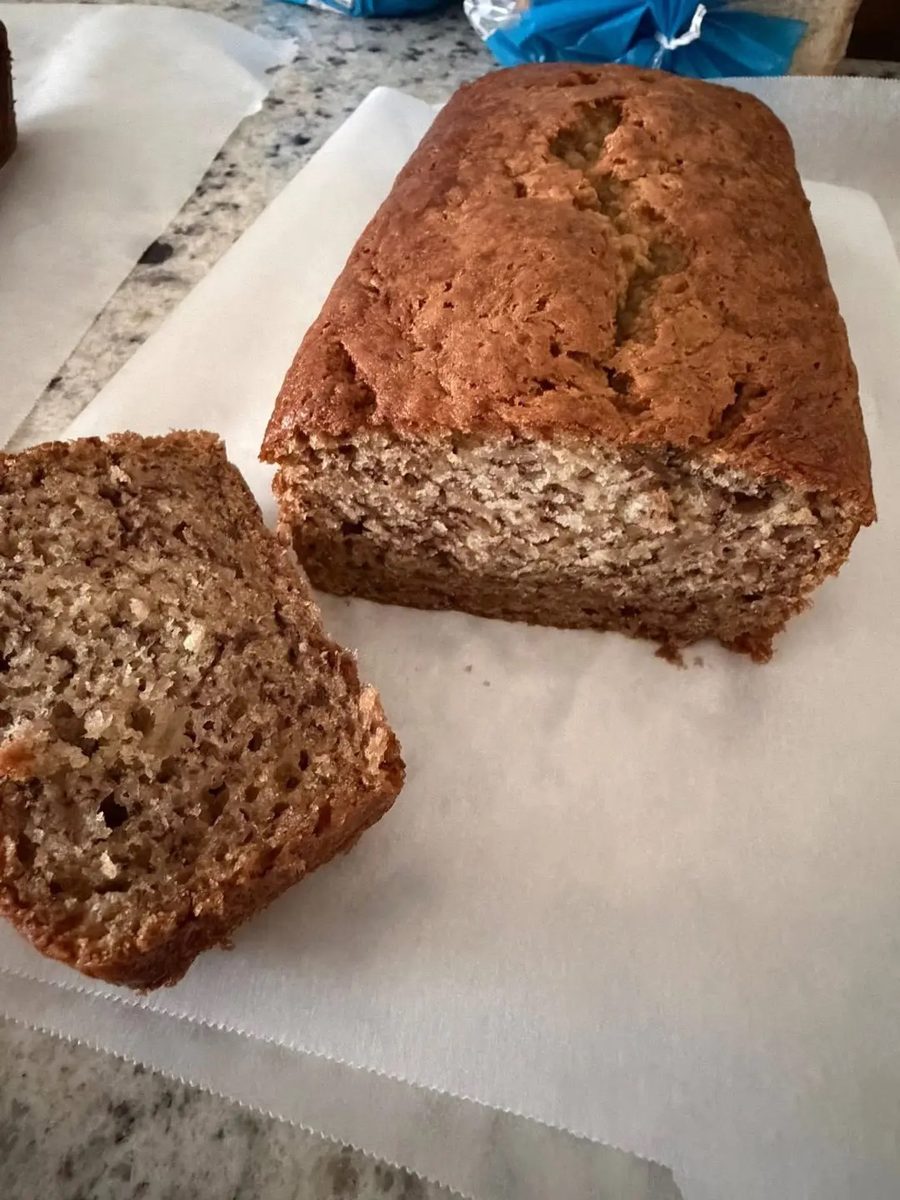Loaf of banana bread with a thick slice cut from the end, showing a soft open crumb